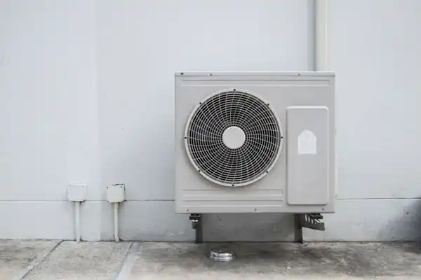 Outdoor air conditioning unit mounted on a concrete wall.