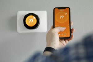 A homeowner controlling their smart thermostat from their phone.